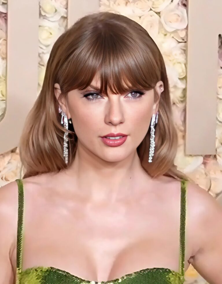 Close-up of a woman with bangs and dangling earrings wearing a green dress in front of a floral backdrop.
