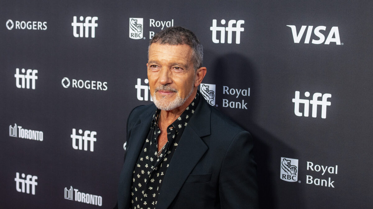A man in a dark floral shirt and blazer poses at a TIFF 2026 step-and-repeat backdrop.