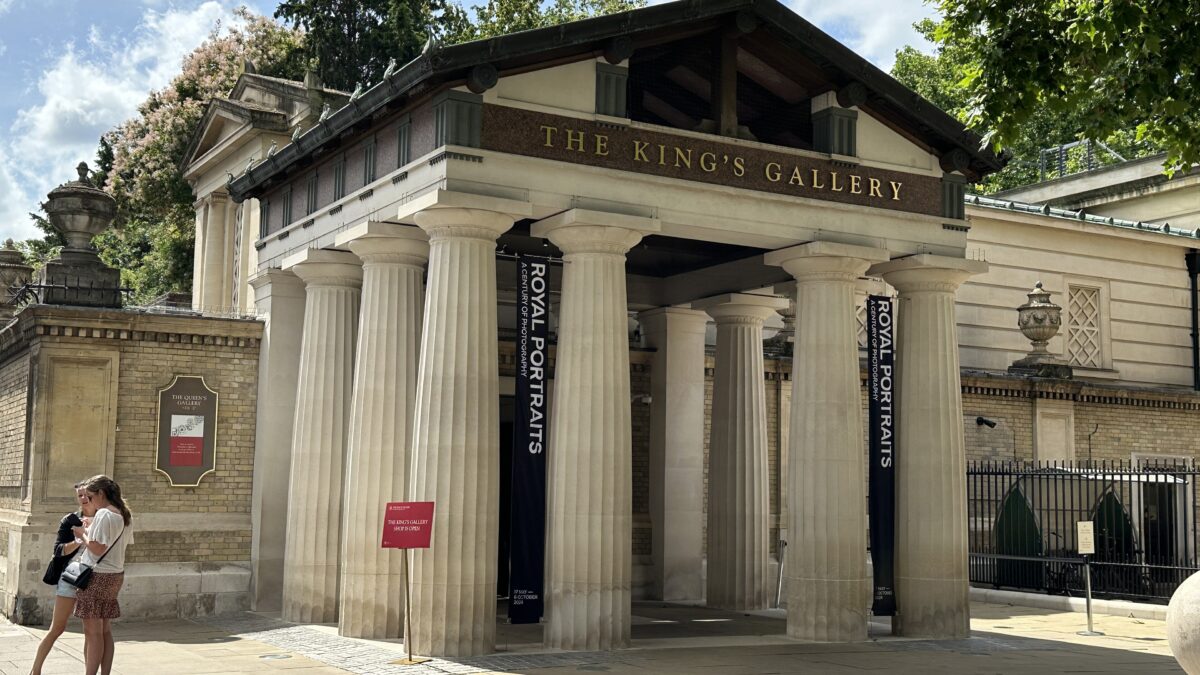 Exterior entrance of The King's Gallery with columns and banners reading Royal Portraits, with visitors walking past.