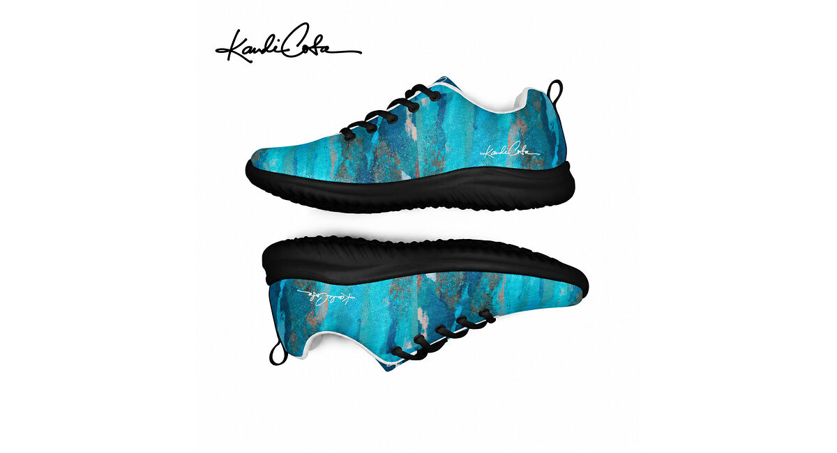 A pair of blue-and-black painted sneakers shown from side and sole views with a signature logo.