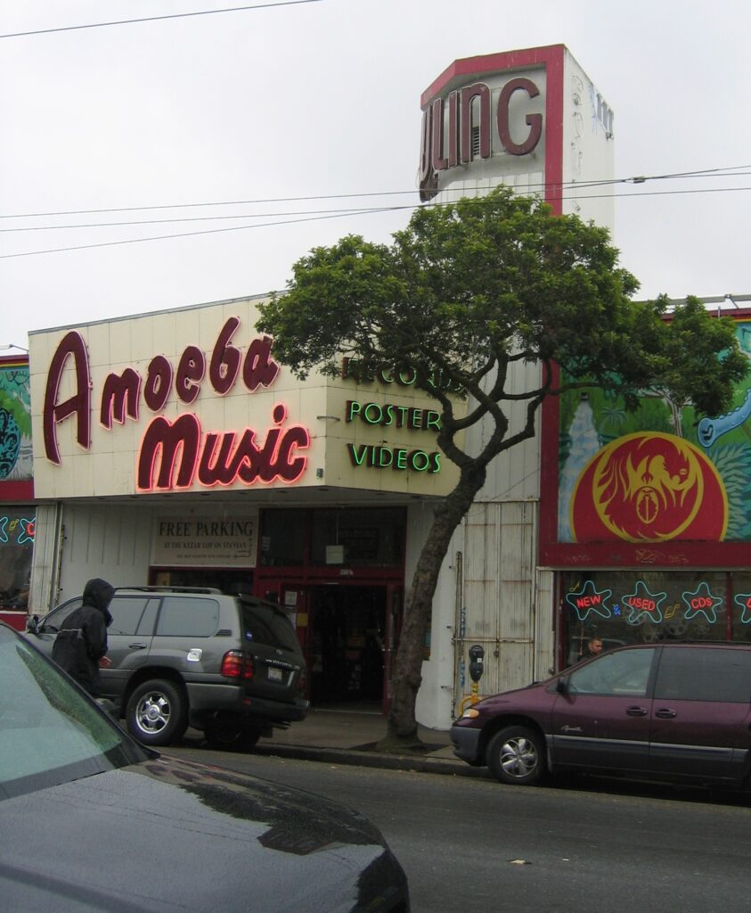 Exterior facade of the Amoeba Music record store on Haight Street in San Francisco with cars parked outside.